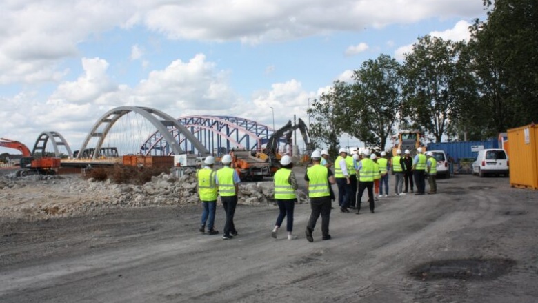 Die Duisburger CDU-Politiker, ausgestattet mit Helm und Warnweste, beim Rundgang über die Baustelle. Im Hintergrund gut zu erkennen, die alten und neuen Brücken.